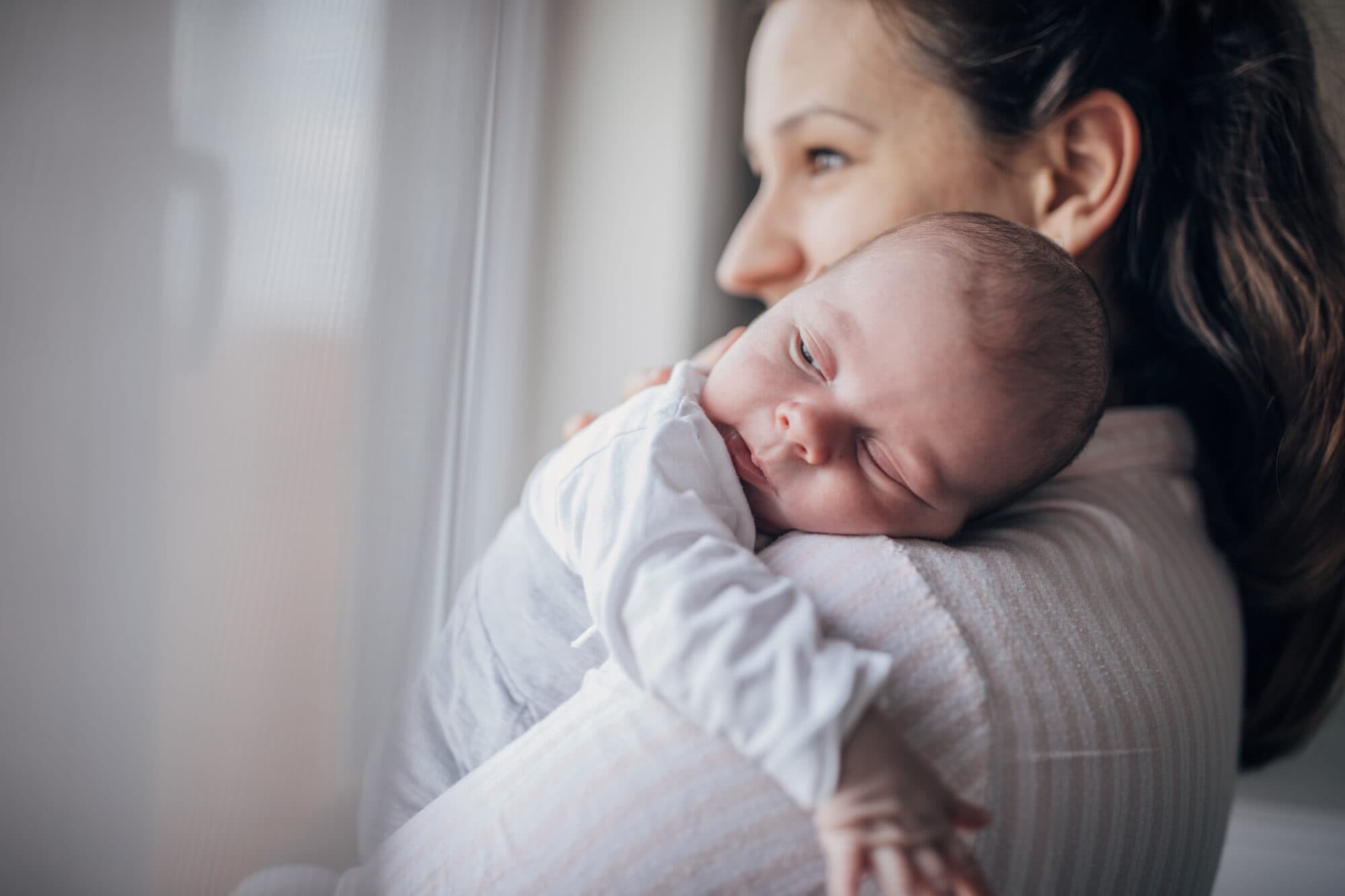 Mother with newborn baby by a window