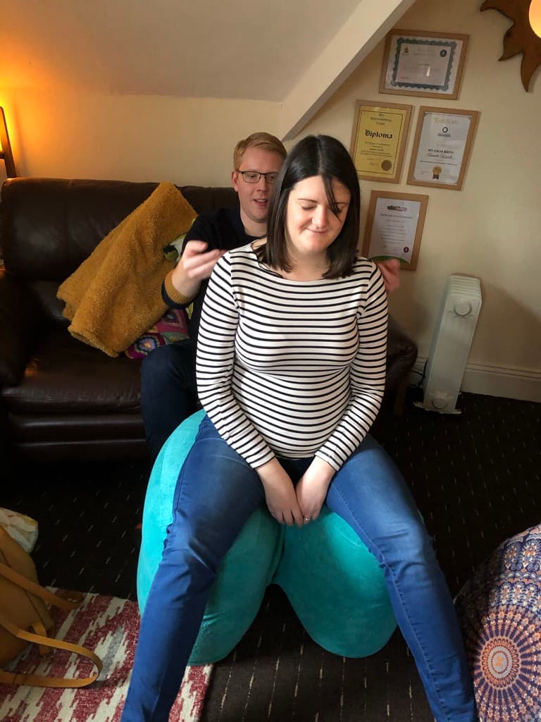 Couple practising hypnobirthing techniques on a birthing ball