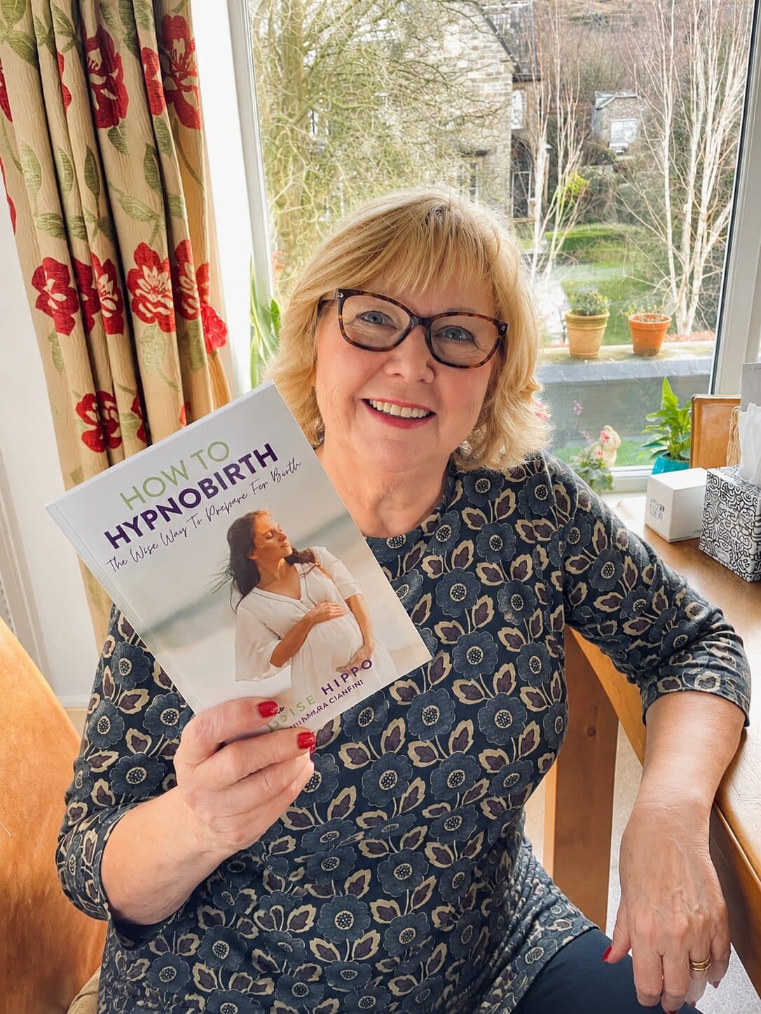Amanda Wardle holding the Wise Hippo hypnobirthing book